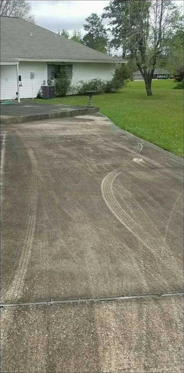 Concrete driveway darkened with ground-in dirt before cleaning