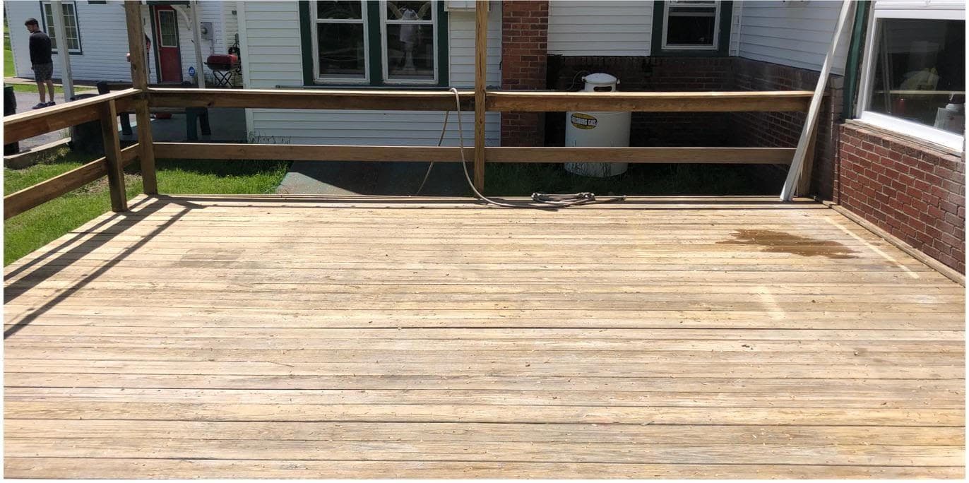 The same deck after cleaning, the boards back to bare golden timber