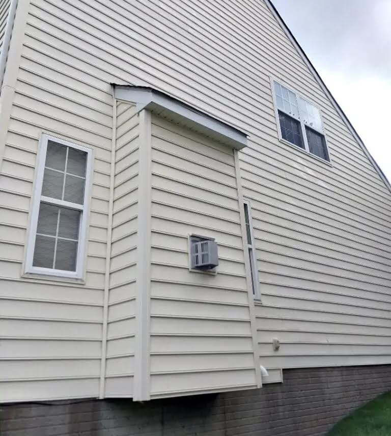 The same wall soft washed back to clean cream siding